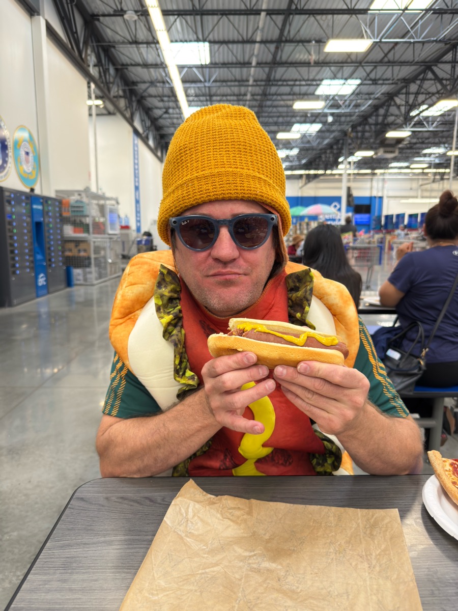 DaWei in a hot dog costume enjoying a hot dog
